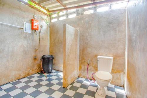 La salle de bains est pourvue de toilettes et d'un sol en damier. dans l'établissement OYO 1155 Bikers House and Enduro Tours Chiang Mai, à Chiang Mai
