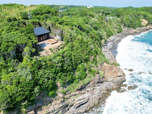 an aerial view of a house on a cliff next to the ocean at UMIBE Terrace in Shima