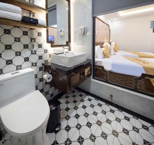 ein Badezimmer mit Toilette, Waschbecken und Spiegel in der Unterkunft Da Lat Prince in Khu Chi Lăng