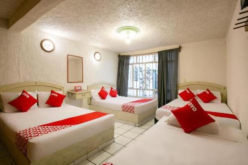 a hotel room with two beds with red pillows at OYO La Casita in Quinceo