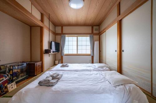 a bedroom with a large bed with towels on it at Kotonoha in Otaru