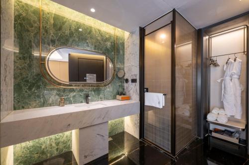 a bathroom with a sink and a mirror at Yuexuan Hotel Chongqing Jiefangbei Hongyadong Branch in Chongqing
