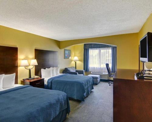 a hotel room with two beds and a television at Quality Inn & Suites Grand Prairie South in Florence Hill