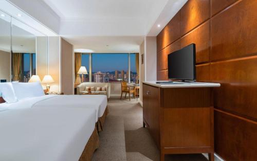 a hotel room with a bed and a flat screen tv at Kai Wah Plaza International Hotel in Kunming