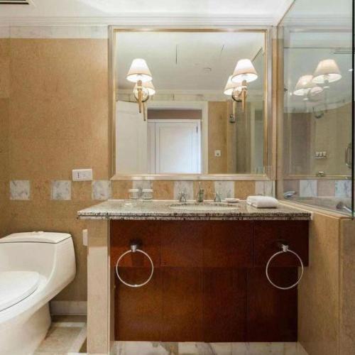a bathroom with a sink and a toilet and a mirror at Kai Wah Plaza International Hotel in Kunming