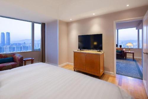 a hotel room with a large bed and a flat screen tv at Kai Wah Plaza International Hotel in Kunming
