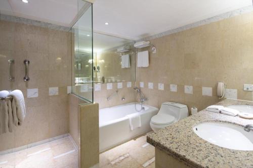 a bathroom with a tub and a toilet and a sink at Kai Wah Plaza International Hotel in Kunming