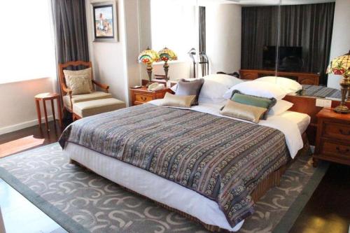 a bedroom with a large bed and a desk at Kai Wah Plaza International Hotel in Kunming