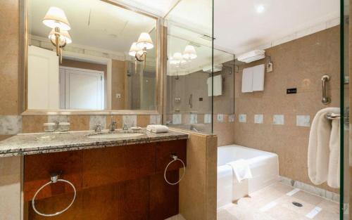 a bathroom with a tub and a sink and a bath tub at Kai Wah Plaza International Hotel in Kunming