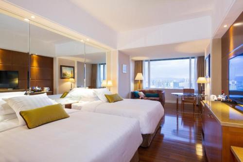 a hotel room with two beds and a desk at Kai Wah Plaza International Hotel in Kunming