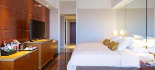 a hotel room with a bed and a flat screen tv at Kai Wah Plaza International Hotel in Kunming