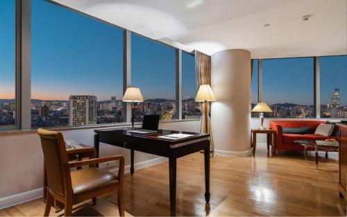a room with a desk with a laptop on it at Kai Wah Plaza International Hotel in Kunming