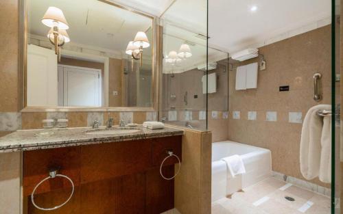 a bathroom with a tub and a sink and a bath tub at Kai Wah Plaza International Hotel in Kunming