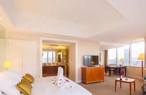 a bedroom with a large bed and a living room at Kai Wah Plaza International Hotel in Kunming