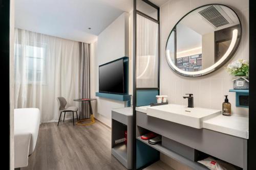 a bathroom with a sink and a mirror at ibis Dongguan Dongcheng in Dongguan