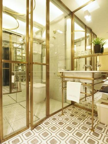 a bathroom with a shower and a toilet and a sink at King's Hotel in Hong Kong