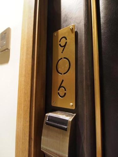 a close up of a door number with a trash can at King's Hotel in Hong Kong