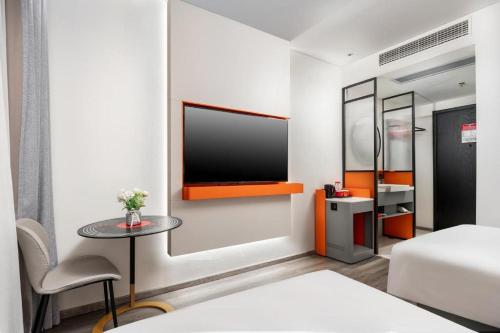 a bedroom with a bed and a table and a tv at ibis Dongguan Dongcheng in Dongguan