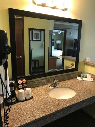 a bathroom counter with a sink and a large mirror at Best Western Rama Inn in Ephrata