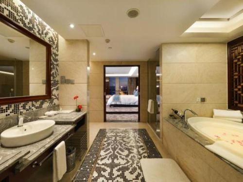 a bathroom with a tub and a sink and a bed at Gaosu New Century Hotel International Anhui in Hefei