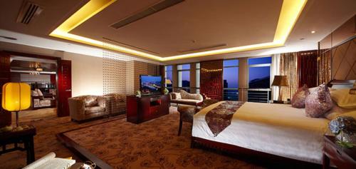 a bedroom with a large bed and a living room at Gaosu New Century Hotel International Anhui in Hefei