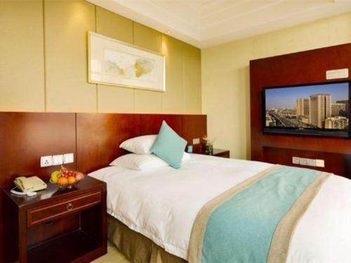 a hotel room with a large bed and a flat screen tv at Gaosu New Century Hotel International Anhui in Hefei