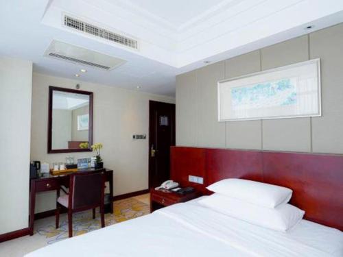 a bedroom with a bed and a desk and a bed sidx sidx sidx at Gaosu New Century Hotel International Anhui in Hefei