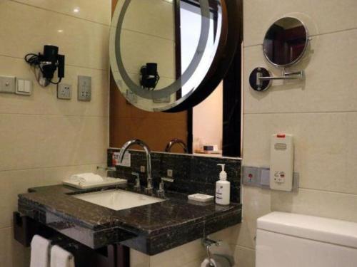 a bathroom with a sink and a mirror at Gaosu New Century Hotel International Anhui in Hefei