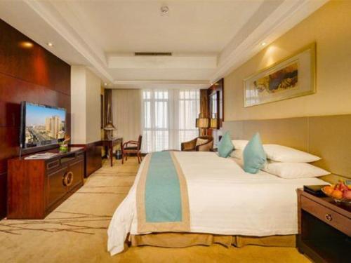 a hotel room with a large bed and a television at Gaosu New Century Hotel International Anhui in Hefei