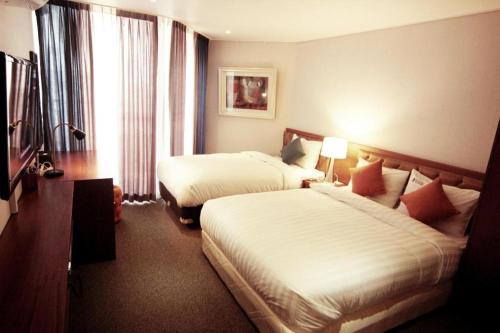 a hotel room with two beds and a window at Hotel One Byeonsan in Buan