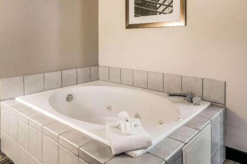 a white bath tub with a towel on it at Suburban Studios Mason Hwy 42 in Mason