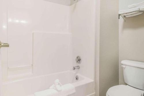 a bathroom with a toilet and a tub and a sink at Suburban Studios Mason Hwy 42 in Mason