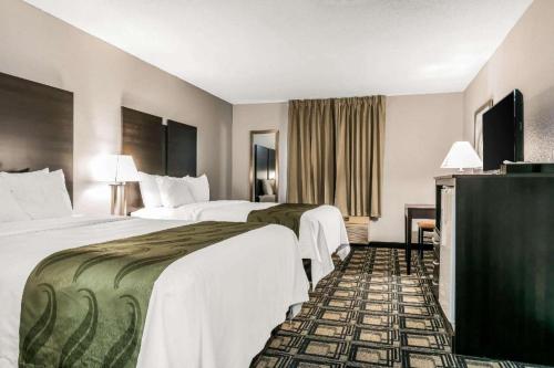 a hotel room with two beds and a television at Suburban Studios Mason Hwy 42 in Mason