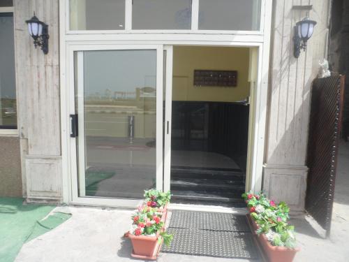 a glass door with two potted plants in front of it at Royal Crown Hotel عائلات فقط in Alexandria