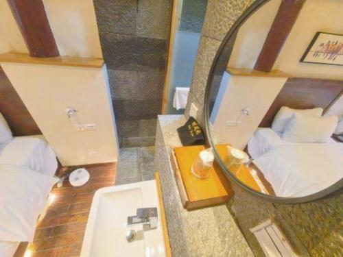 Shangrila Agedtree Hotel في شانغريلا: حمام به مراه وسرير ومغسلة