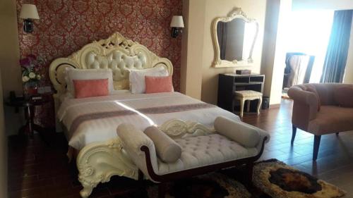 a bedroom with a large white bed and a couch at The Belagri Hotel and Convention in Sorong