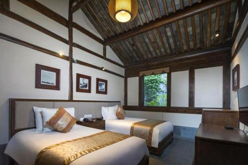 une chambre d'hôtel avec deux lits et un bureau dans l'établissement Ningbo Shi Qi Fang Kaiyuan Hotel, à Ningbo