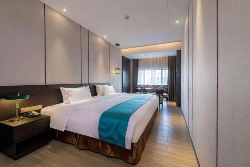 a bedroom with a large bed and a desk at H Life Hotel Nanshan Branch in Shenzhen