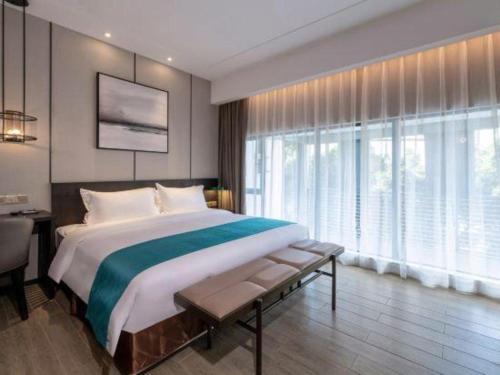 a large bedroom with a large bed and a desk at H Life Hotel Nanshan Branch in Shenzhen