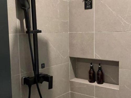 a shower with two bottles in a shower stall at H Life Hotel Nanshan Branch in Shenzhen