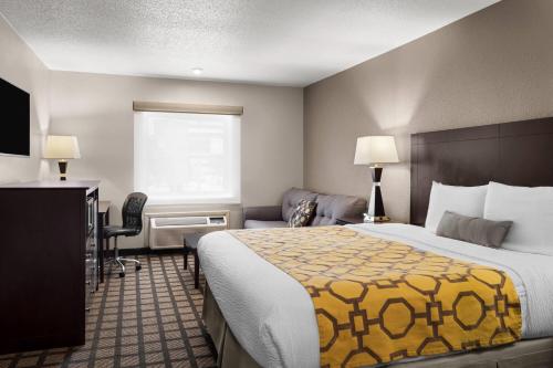 a hotel room with a bed with a yellow blanket at Baymont by Wyndham Jefferson City in Jefferson City