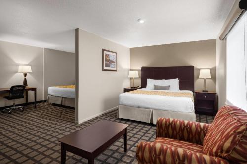 a hotel room with a bed and a couch at Baymont by Wyndham Jefferson City in Jefferson City