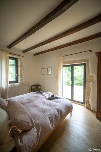 une chambre avec un lit et une grande fenêtre dans l'établissement À Font Aubarne, à Nîmes