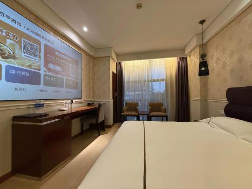 a hotel room with a bed and a projection screen at Yiwu Baiheng Hotel in Yiwu