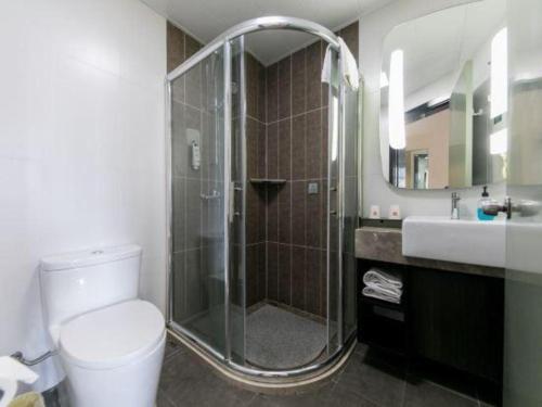 a bathroom with a shower and a toilet and a sink at Ibis Nantong Qingnian in Nantong