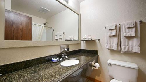 a bathroom with a sink and a toilet and a mirror at Best Western Lake Lucille Inn in Wasilla