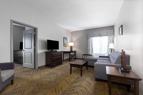 a living room with a couch and a tv at La Quinta by Wyndham Brookshire West Katy in Brookshire