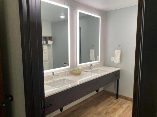 a bathroom with two sinks and a large mirror at Best Western Lake Lucille Inn in Wasilla