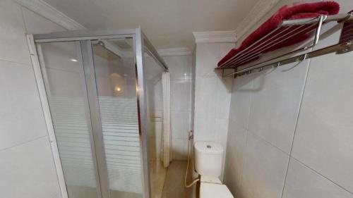 une salle de bain blanche avec douche et toilettes dans l'établissement Madani Hotel Medan, à Medan