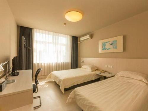 長春市にあるJinjiang Inn Changchun Pepole Squareのベッド2台とテレビがあるホテルの部屋